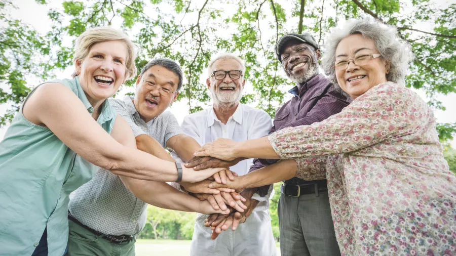 A group of five seniors stack hands on top of one another